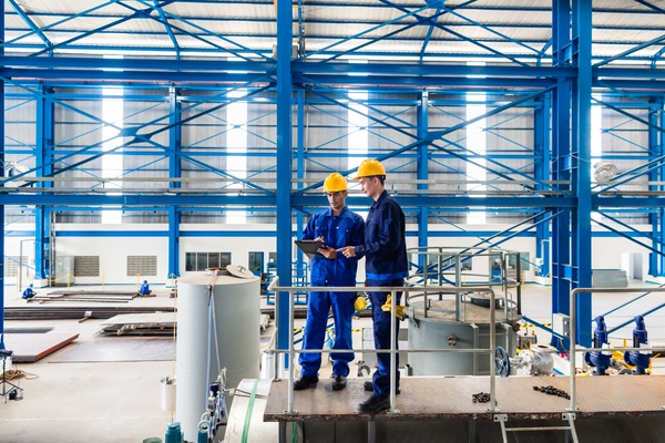 Workers reviewing factory equipment